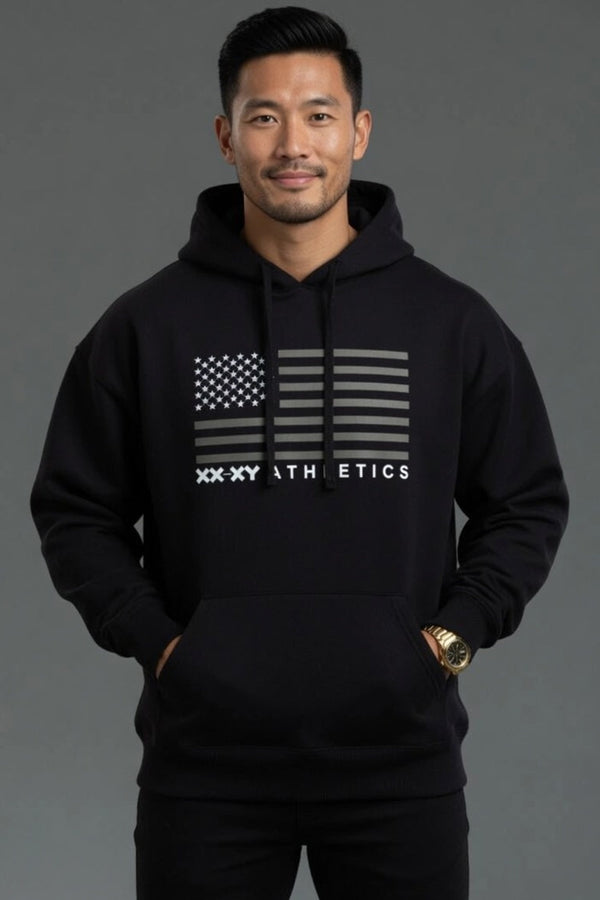 Man wearing a black hoodie with a flag design and 'XXXY Athletics' text on a gray background || Black