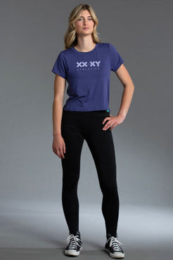 Woman wearing Blue t-shirt with a logo and black leggings || Indigo