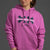 Person wearing a pink hoodie with text on a gray background || Bright Fuchsia