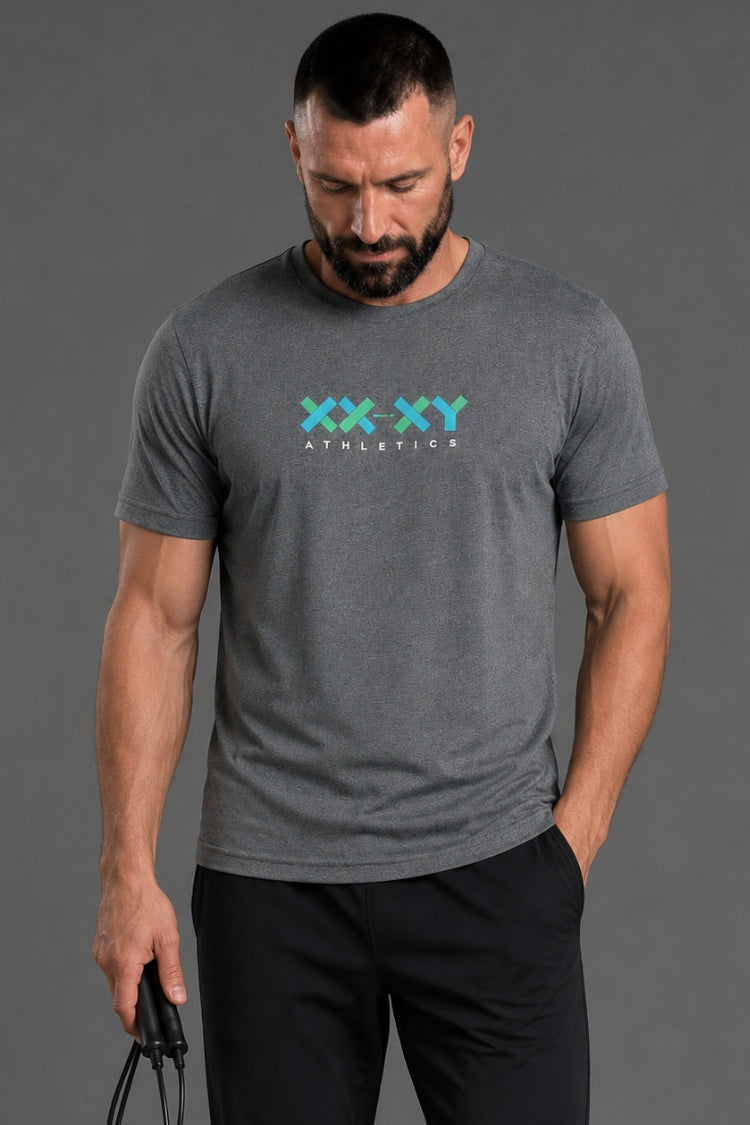 Man wearing a gray t-shirt with 'XXY Athletics' logo on a gray background