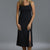 Woman wearing a black sleeveless dress with a slit on a gray background || Black