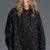 Woman wearing a black camouflage hoodie on a gray background || Black Camo