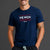Man standing in front of gray background wearing a navy tshirt with WE WON text on it. || Navy