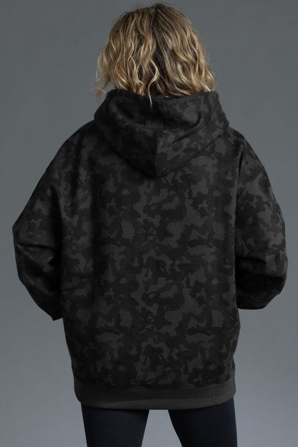 Person wearing a black camouflage jacket against a gray background || Black Camo