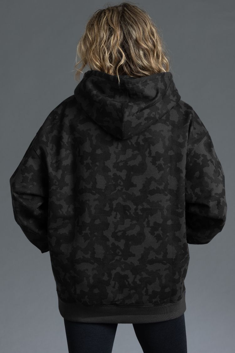 Person wearing a black camouflage jacket against a gray background || Black Camo