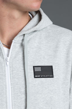 Gray hoodie with a logo patch on the chest against a neutral background || Light Heather Gray