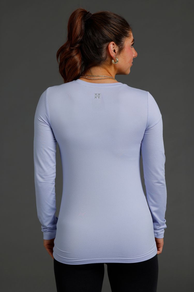 Woman wearing lavender long-sleeve shirt against a gray background || lavender gray