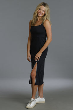Woman wearing a black dress with a slit on a gray background || Black