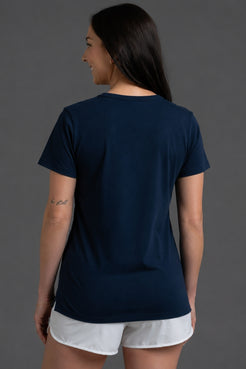 Woman wearing a navy blue t-shirt and white shorts on a gray background || Navy