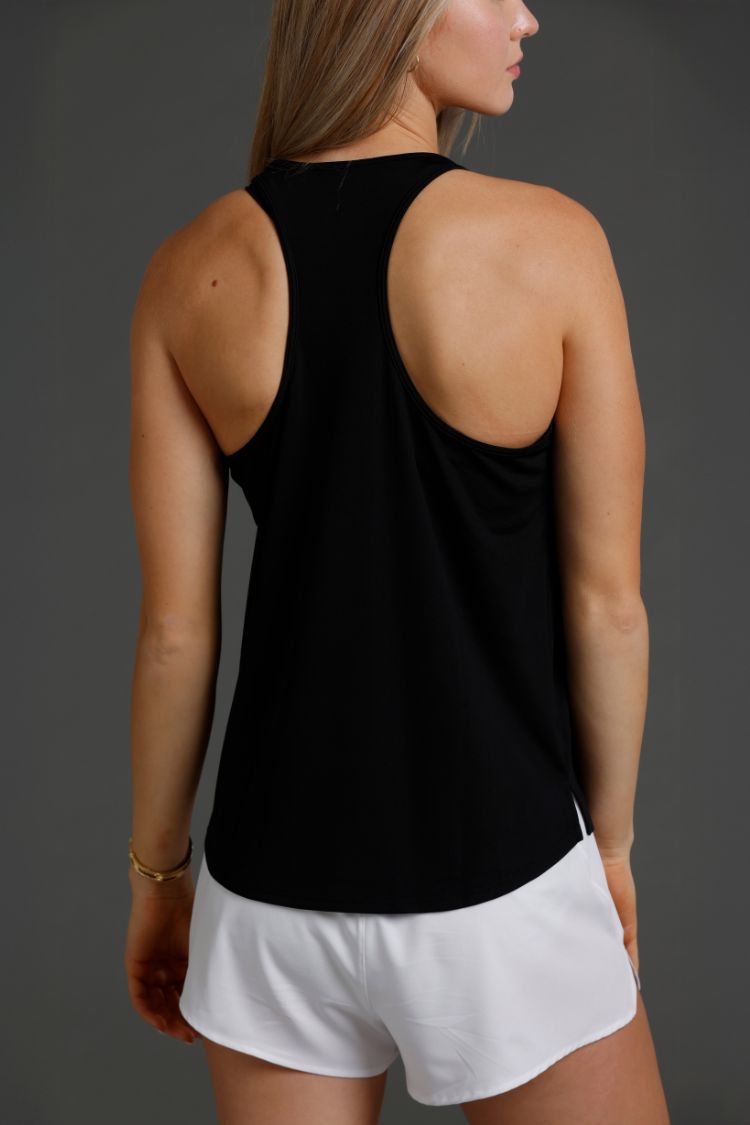 Person wearing a black tank top and white shorts on a gray background || Black