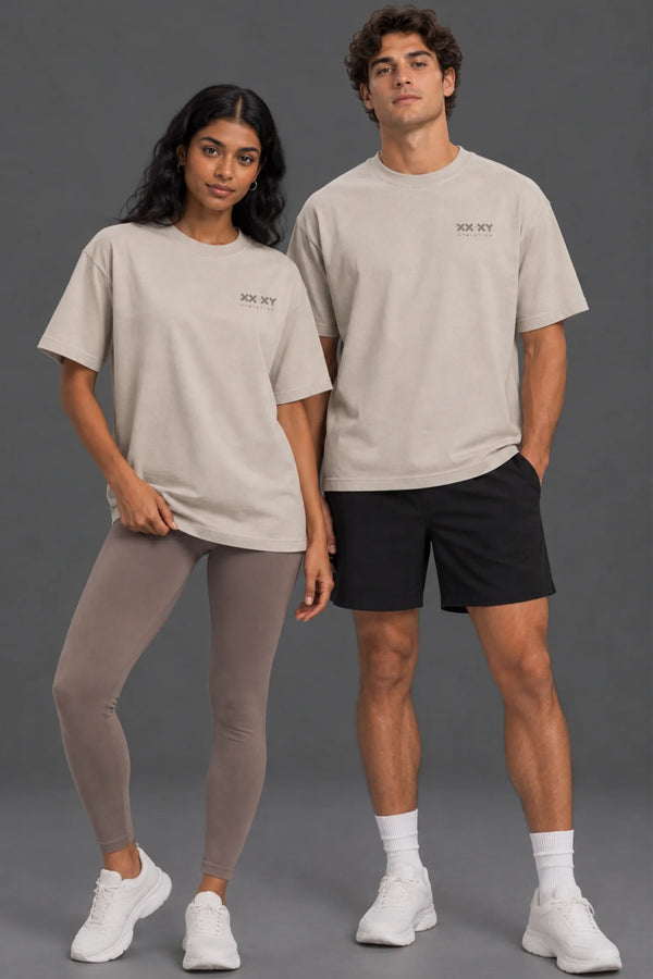 Female and male models wearing stone Save Women’s Sports graphic tees with athletic bottoms. || Dune