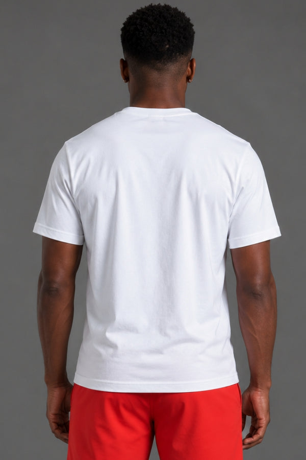 A man viewed from behind wearing a plain white short-sleeve crewneck t-shirt and bright red shorts, standing against a solid gray studio background. || White