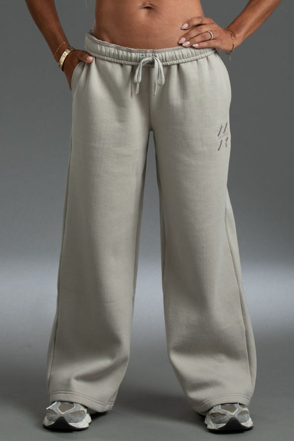 Person wearing light gray sweatpants on a gray background || taupe