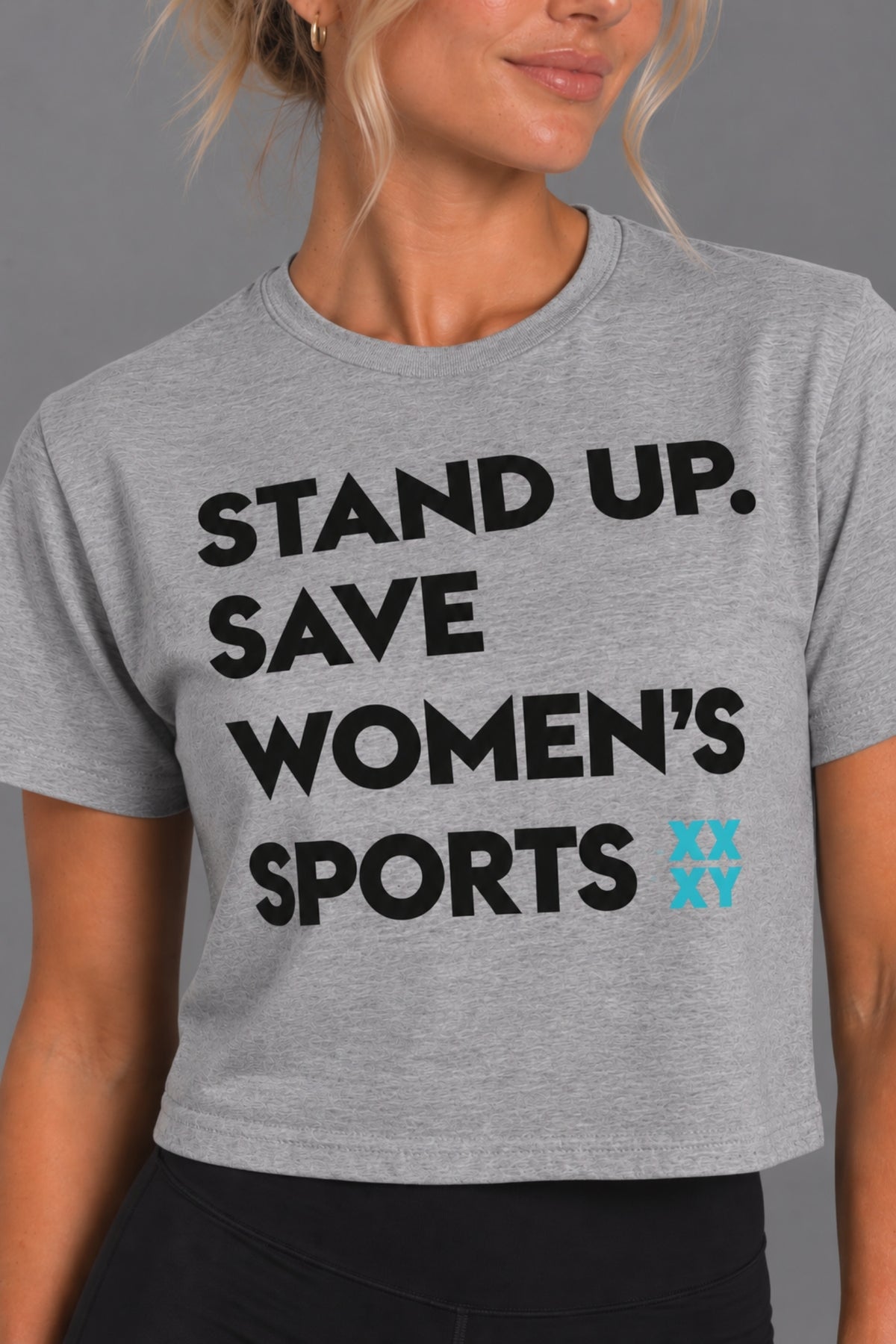 Blonde woman modeling the gray cropped Stand Up Save Women’s Sports graphic tee