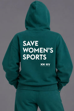 Back view of a woman wearing a teal hoodie with the hood up, featuring “SAVE WOMEN’S SPORTS” and the XX-XY Athletics logo in white. || Pine