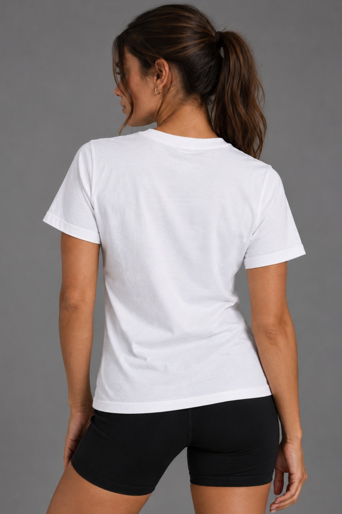 Back view of woman wearing the white Save Women’s Sports tee with black bike shorts