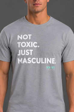 A man wearing a heather gray crewneck t-shirt with the text 'NOT TOXIC. JUST MASCULINE. || Light Heather Gray