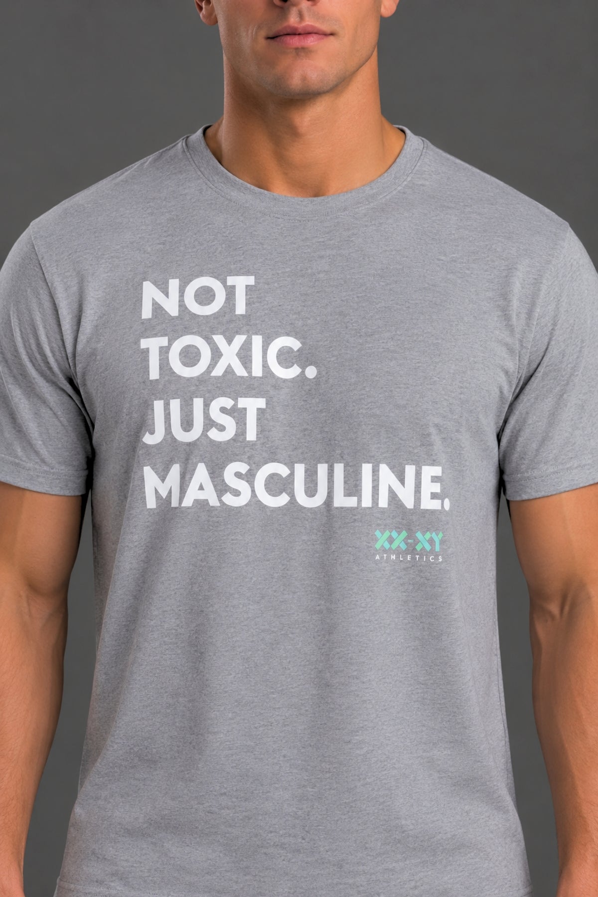 A man wearing a heather gray crewneck t-shirt with the text 'NOT TOXIC. JUST MASCULINE. || Light Heather Gray