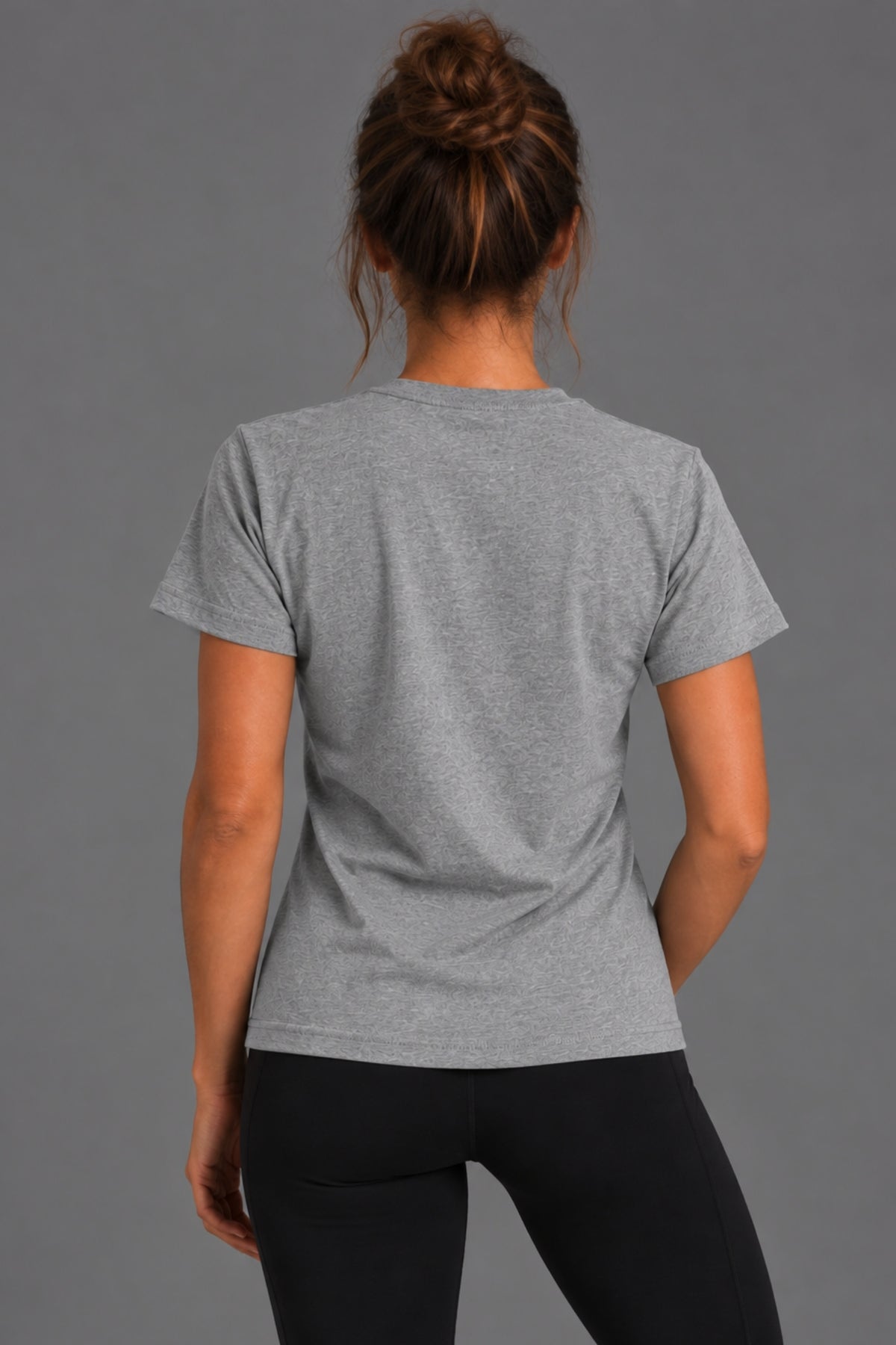 Back view of woman wearing the gray Stand Up Save Women’s Sports tee with black leggings