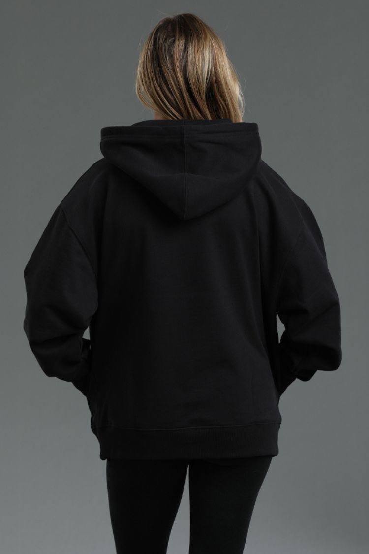 Person wearing a black hoodie against a gray background || Black