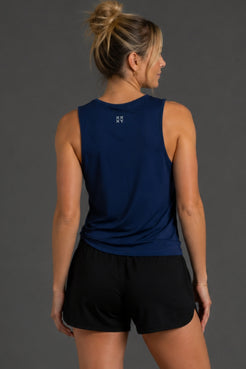 Woman wearing a blue sleeveless top with 'USA' logo against a gray background || Navy