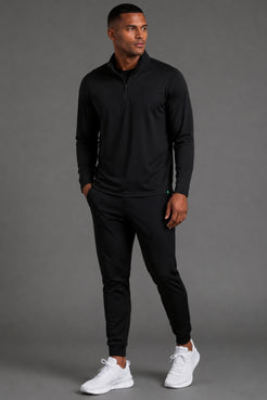 Male model showcasing black athletic joggers with a streamlined tapered fit and cuffed ankles. || Black
