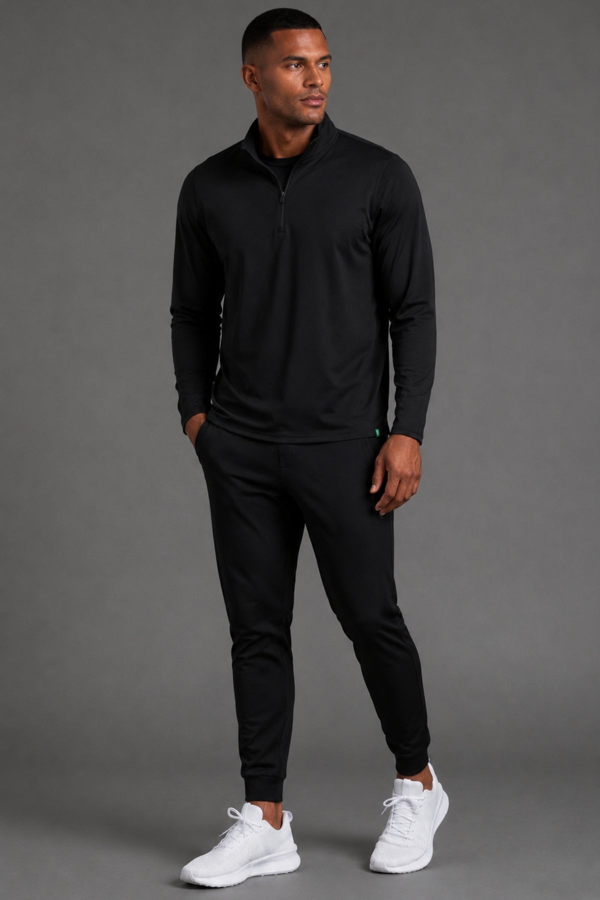 Male model showcasing black athletic joggers with a streamlined tapered fit and cuffed ankles. || Black