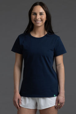 Woman wearing a navy blue t-shirt and white shorts on a gray background || Navy