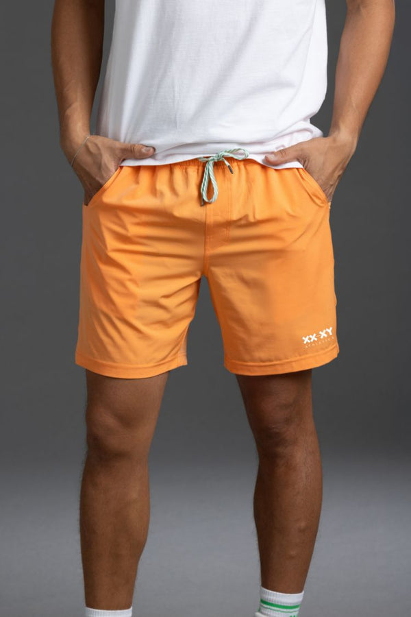Person wearing orange shorts with a gray background || Light Orange