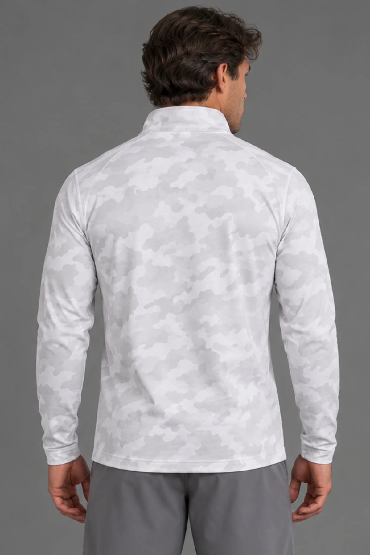 Back view of a male model wearing a white camo quarter-zip pullover with gray athletic shorts. || White Camo