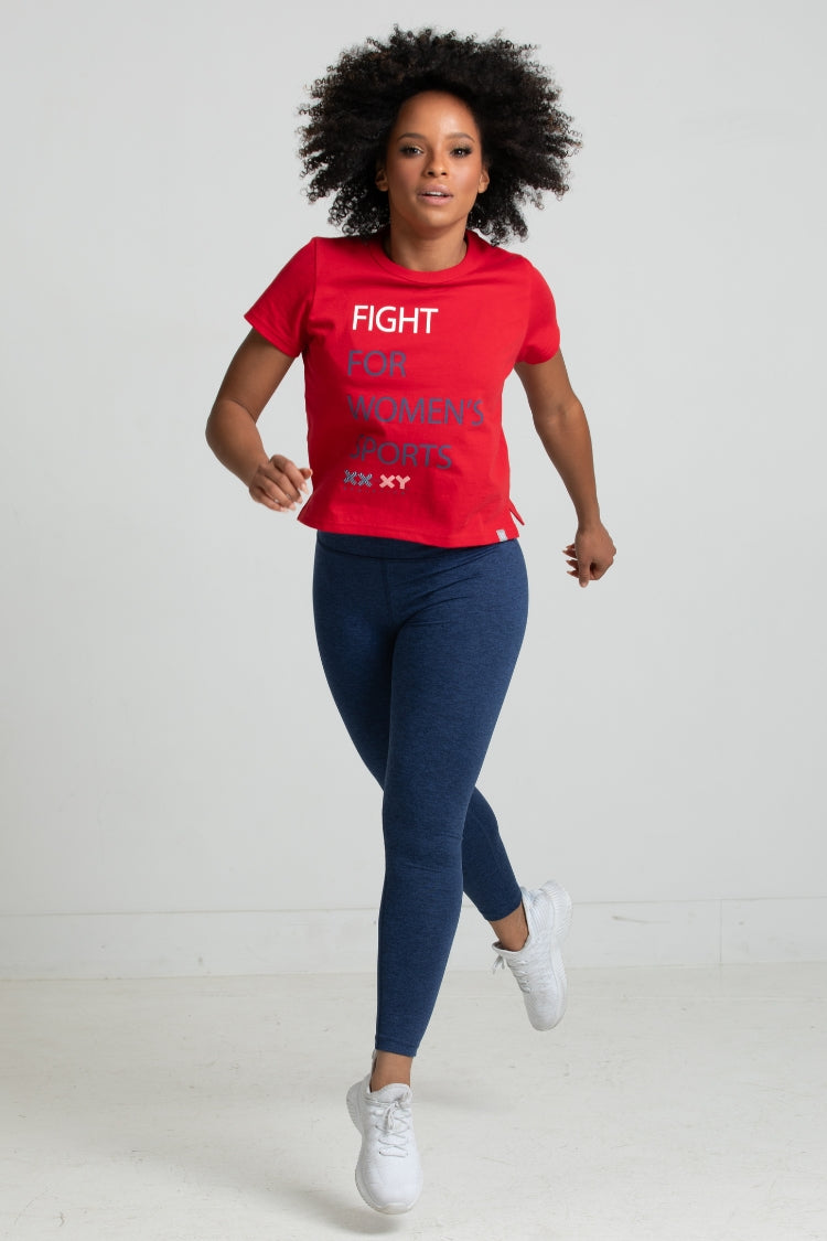 Person wearing a red t-shirt with text and blue leggings on a white background || Red