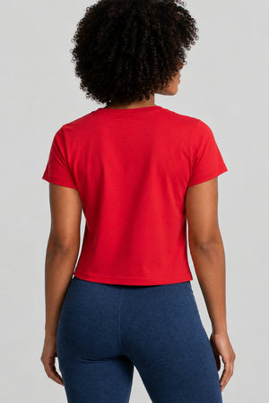 Person wearing a red t-shirt and blue leggings on a light gray background || Red