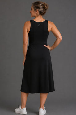 Woman wearing a black sleeveless dress against a gray background || Black