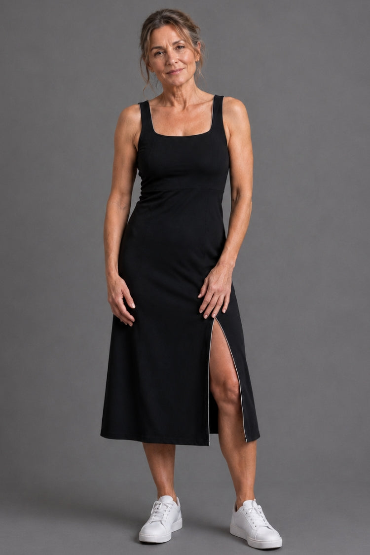 Woman wearing a black sleeveless dress with a slit on a gray background || Black