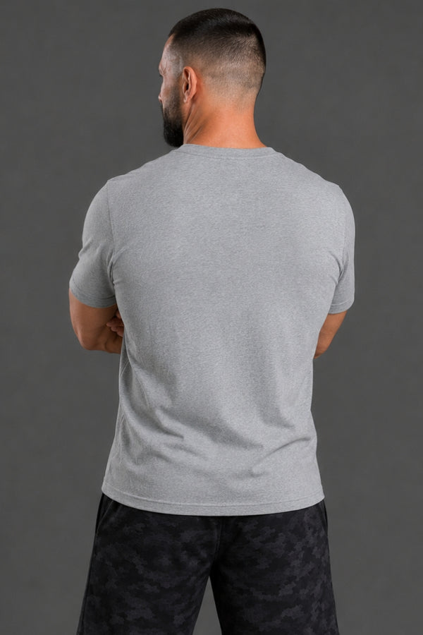 Man wearing a gray t-shirt and black patterned pants against a gray background || Light Heather Gray