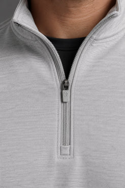 Close-up of a light gray heathered quarter-zip pullover with a silver zipper pull, worn over a black shirt. || Light Heather Gray - 1