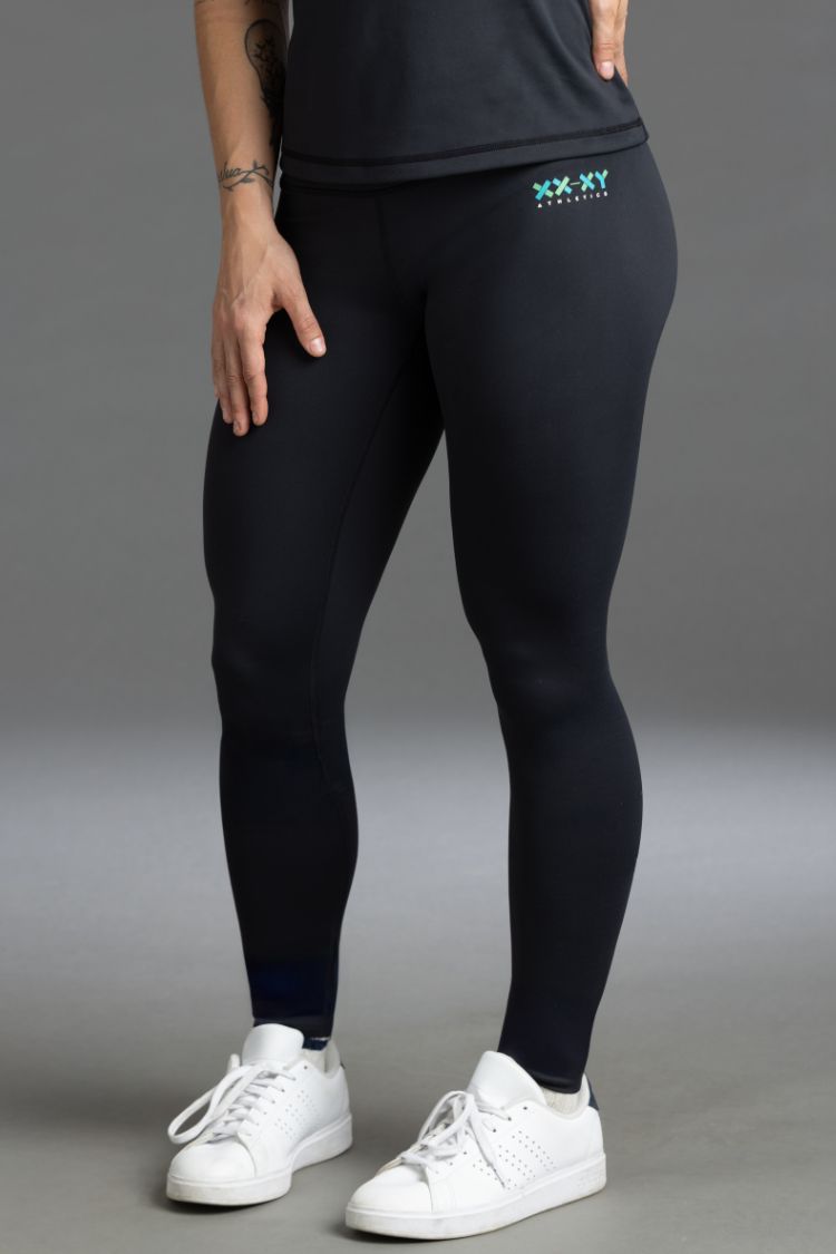 Person wearing black leggings with a logo and white sneakers  || Black