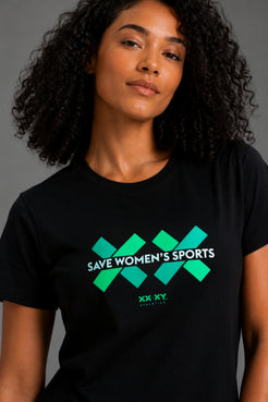 A woman with curly black hair wearing a black short-sleeve t-shirt with a green and white graphic that reads 'SAVE WOMEN'S SPORTS' and 'XX XY'. || Black