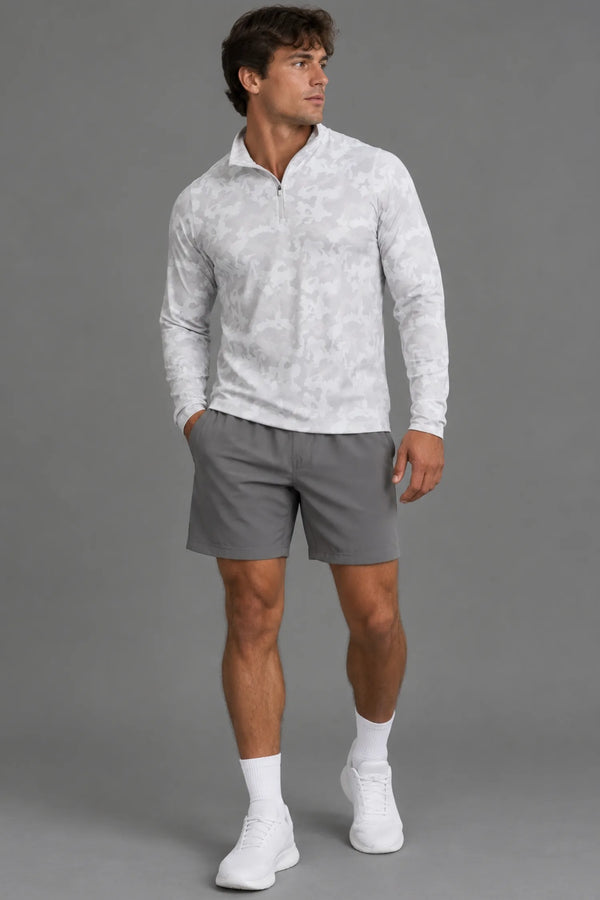 Male model wearing a white camo quarter-zip pullover with gray athletic shorts, white socks, and white sneakers. || White Camo