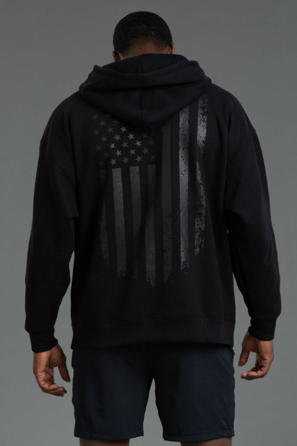 Person wearing a black hoodie with an American flag design on the back || Black