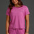 Woman wearing a pink t-shirt and shorts set with a brand logo || Bright Fuchsia