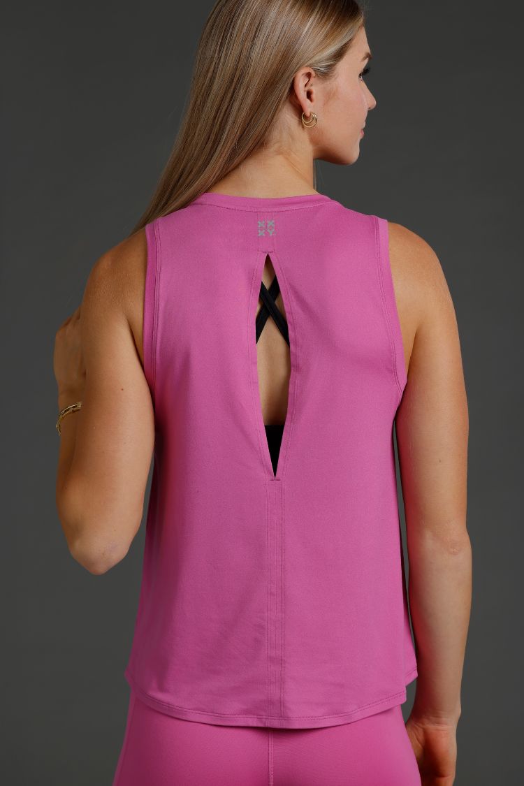 Woman wearing a pink sleeveless top with a cut-out design on a dark background || Bright Fuchsia