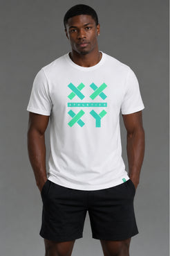 A man wearing a white crewneck t-shirt with a green and teal graphic on the chest that reads 'XX ATHLETICS XY' and black athletic shorts, standing against a solid gray studio background. || White