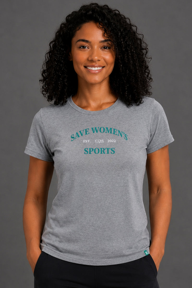 A smiling woman with curly black hair wearing a heather gray t-shirt with 'SAVE WOMEN'S SPORTS' printed in teal on the chest, posed against a solid gray studio background. || Heather Gray