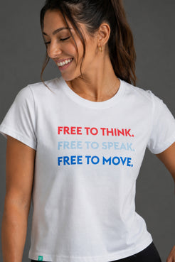 A woman wearing a white graphic t-shirt with the text 'FREE TO THINK. FREE TO SPEAK. || White