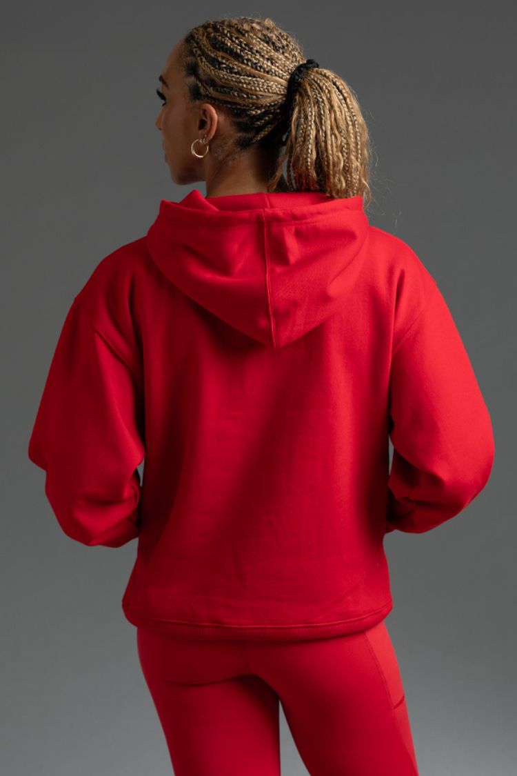 Person wearing a red hoodie and pants on a gray background || red