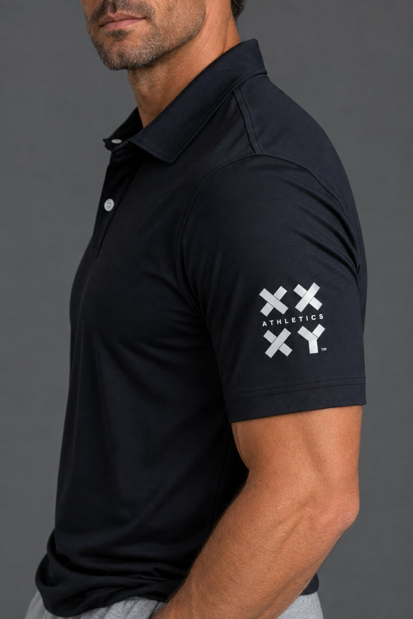 A man wearing a dark navy short-sleeve polo shirt with a white XXYY Athletics logo on the left sleeve, shown in a side profile against a dark gray background. || Black