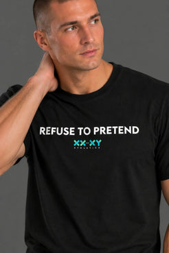 Male model wearing a black "REFUSE TO PRETEND" XX-XY Athletics T-shirt and black shorts, standing with one hand in his pocket and looking to the side. || Black