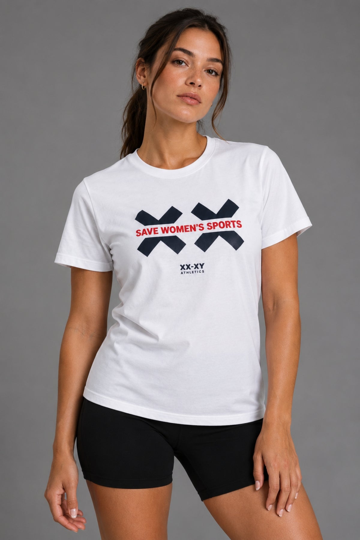 Woman wearing the white Save Women’s Sports graphic tee with black bike shorts || White
