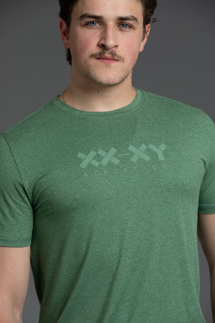 Man wearing a green t-shirt with a xx-xy logo on a gray background || Hunter Green Heather